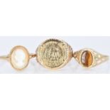 Three 9ct gold rings, one set with tiger's eye, one a cameo and a Mexican replica coin, 6.5g, size