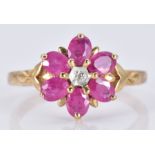 A 9ct gold ring set with oval rubies and a diamond in a flower cluster, 2.6g, size N