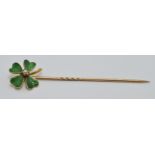 Victorian yellow metal stick pin set with green enamel and a seed pearl in the form of a four leaf