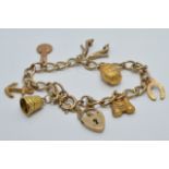 A 9ct gold charm bracelet with seven 9ct gold charms including horse shoe, barrel, binoculars etc,