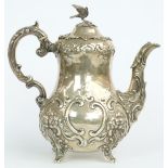 Victorian hallmarked silver teapot with bulbous body and embossed decoration, raised on four feet