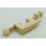 A 19thC ivory sewing / needlework clamp, height 12cm with cotton spool