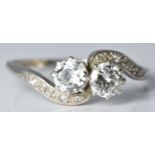 An early 20thC platinum ring set with two diamonds, each approximately 0.4ct, with diamond encrusted