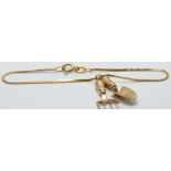 A 9ct gold bracelet with two 9ct gold charms depicting a trowel and fork, 2.9g
