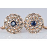 A pair of yellow metal earrings set with a blue and white sapphires in a cluster