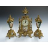 A brass clock garniture with decorated porcelain panels, a 20thC reproduction of an 18thC design,