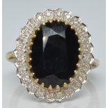 A 9ct gold ring set with a large oval sapphire surrounded by diamonds, 5.1g, size M/N