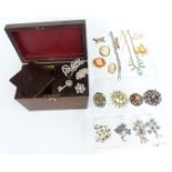 A collection of costume jewellery, including brooches, diamanté etc, in a wooden tea caddy