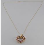 A 9ct gold heart pedant set with alternating rubies and diamonds on a 9ct gold chain, 3g
