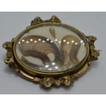 Victorian mourning brooch within a scrolling border set with hair, 5 x 4.2cm