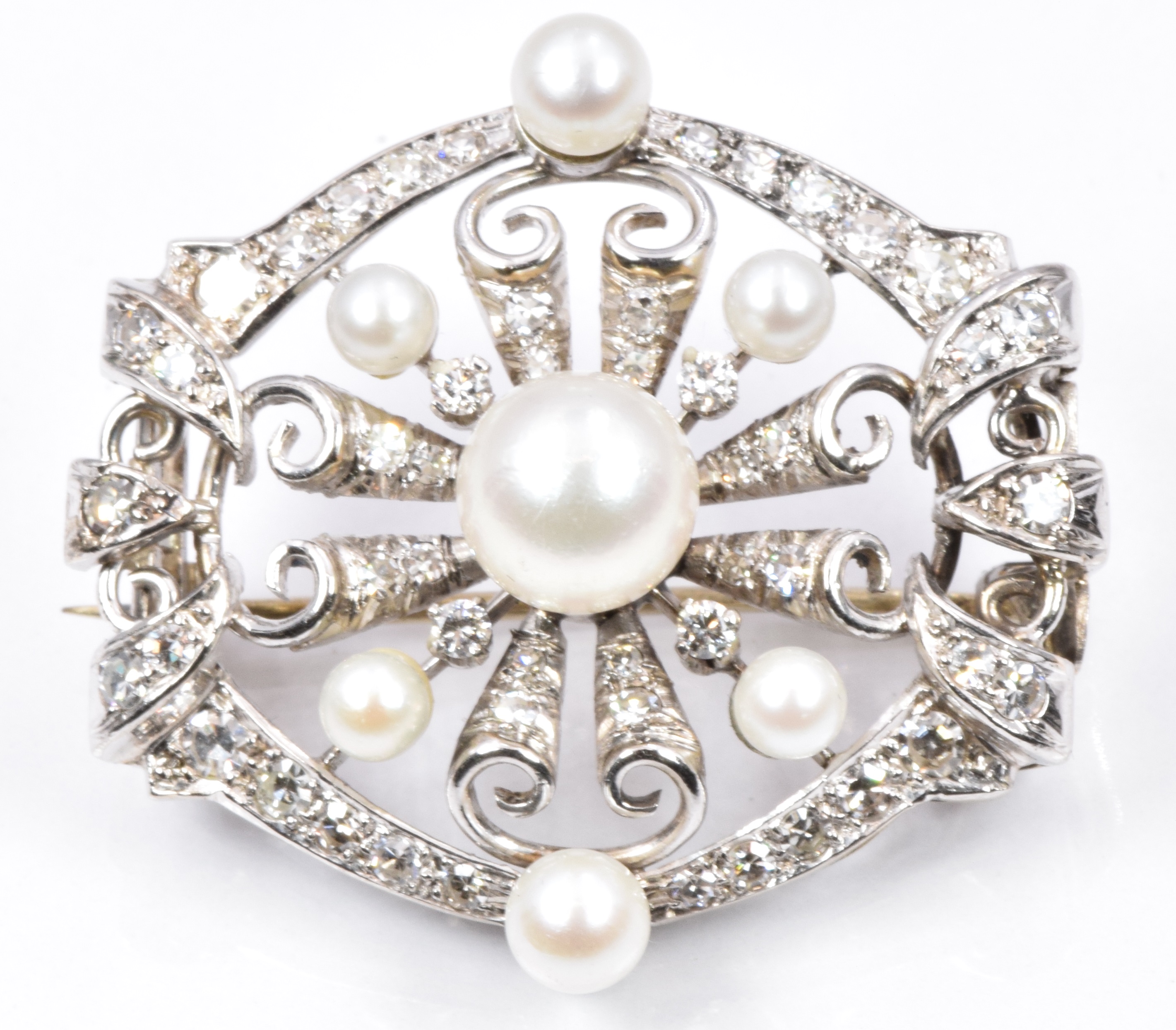 A 1930s 18ct white gold brooch set with pearls and diamonds. 11g, 3cm diam