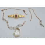 A 9ct gold necklace (1g) and a 9ct gold brooch set with amethyst and seed pearls (1.9g)