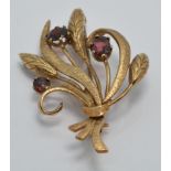 A 9ct gold brooch set with garnets in a bouquet design, 9.7g
