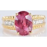 An 18ct gold ring set with an oval cut ruby and diamonds, 7.7g, size N