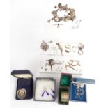 A collection of silver jewellery including charm bracelet, fob, brooches, cross, silver chain,