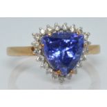 A 9ct gold ring set with a trillion cut tanzanite surrounded by diamonds, 3.2g, size O