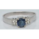 A white gold ring set with an oval cut sapphire and four diamonds to each shoulder, 3.4g, size R/S
