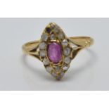Victorian ring set with an oval cut pink sapphire surrounded by diamonds in a marquise shaped
