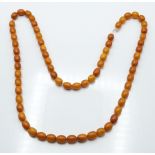 Baltic amber necklace made up of 66 oval beads, 46g