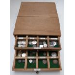 An amateur collection of 19thC and 20thC world coinage contained in a custom-made wooden three-