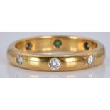 An 18ct gold eternity ring set with an emerald and diamonds, 4.4g, size M