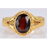 A 22ct gold ring set with an oval garnet, 7.0g, size O