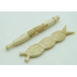 Two 19thC carved ivory needle cases comprising a Meiji period Japanese example with lion