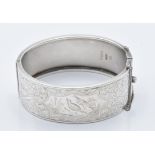 A hallmarked silver bangle with engraved bird and foliate decoration, Birmingham 1935, 33g