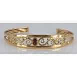 A 9ct gold bangle set with a garnet, 6.4g