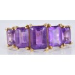A 9ct gold ring set with emerald cut amethysts, 2.4g, size M