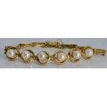 A 14k gold bracelet set with pearls in halos