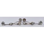 A pair of Art Deco 9ct white gold earrings set with three old cut diamonds, the largest
