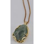 An 18ct gold pendant set with jade (5.1g) on a 9ct gold chain (4.0g)