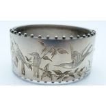 Victorian white metal bangle with engraved decoration depicting birds amongst foliage, stamped