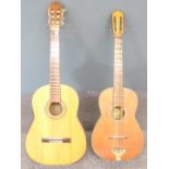 Two acoustic folk guitars, both fitted with six nylon strings, one by Marina, model GK-77, the other