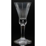 An 18thC wine or ale glass with folded foot, control bubble decoration and thistle shaped bowl, 22cm