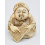 An early 20thC Japanese ivory netsuke depicting a man using an abacus, 3cm