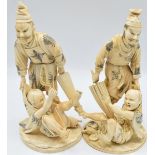 A pair of Japanese Meiji period ivory okimonos of a man with parasol holding a struggling