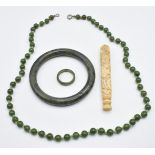 A nephrite jade bangle, necklace and ring together with a carved Chinese bone needle case