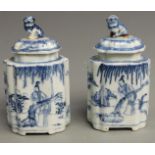 A pair of 19thC Chinese blue and white covered tea caddies with figural decoration and Foo Dog