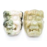 A pair of Chinese Bowenite buckles in the form of masks, 5cm
