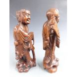 A pair of Chinese carved hardwood figures with bone teeth, H30cm
