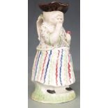 An 18th/19thC Prattware Toby jug of an old woman taking snuff