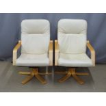 Two faux leather swivel armchairs