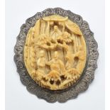 A late 19thC Chinese silver brooch set with a carved ivory plaque