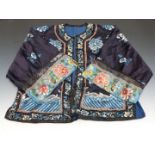 A 19thC Chinese coat with embroidered decoration and embossed brass buttons.