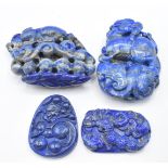 Two Chinese lapis lazuli carvings depicting Foo Dogs and two Chinese lapis lazuli pendants depicting