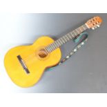 Almeria Spanish folk acoustic guitar fitted with six nylon strings, with embroidered shoulder strap,