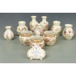 Ten Zsolnay Pecs vases including three with reticulated rims and an advertising plaque, tallest 16cm