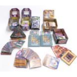 A collection of Pokemon and Yu-Gi-Oh trading cards, some in matching tins and boxes.